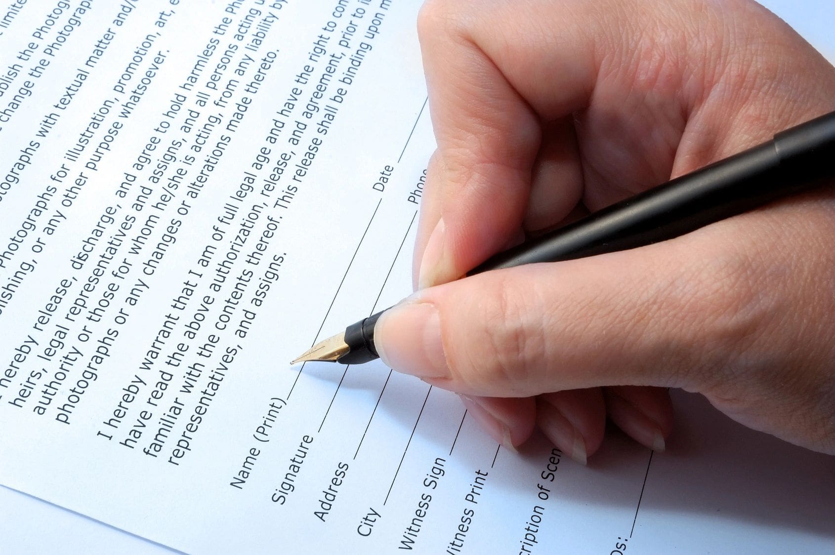 A person writing on top of a paper.